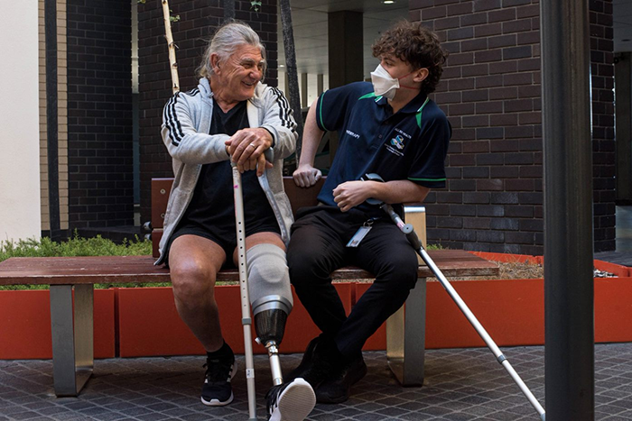 Man with prosthetic leg talking to health professional
